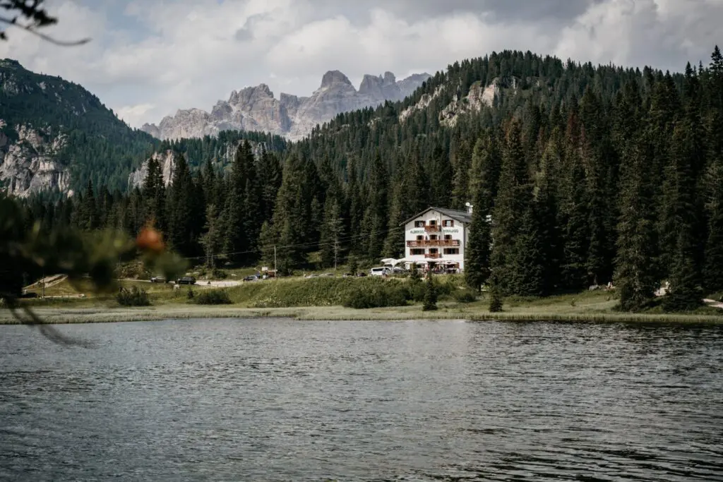 Am See gelegenes Hotel, umgeben von Kiefernwald und den Gipfeln der Dolomiten in Italien