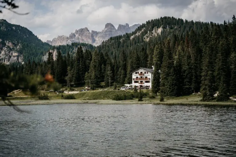 Am See gelegenes Hotel, umgeben von Kiefernwald und den Gipfeln der Dolomiten in Italien