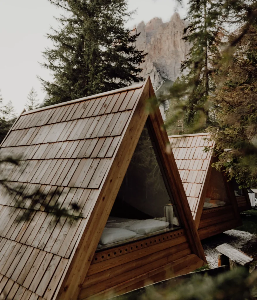 A-förmige Holzhütten zwischen Kiefern in den italienischen Dolomiten